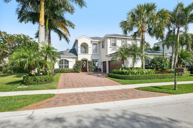 192 Sedona Way, Palm Beach Gardens, FL 33418 - mediterranean / spanish home with decorative driveway, an attached garage, stucco siding, and a front yard