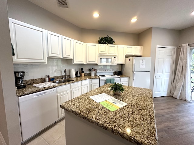 9851 Perfect Dr Unit 151, Port Saint Lucie, FL 34986 - kitchen featuring white appliances, dark stone countertops, white cabinets, decorative backsplash, and recessed lighting