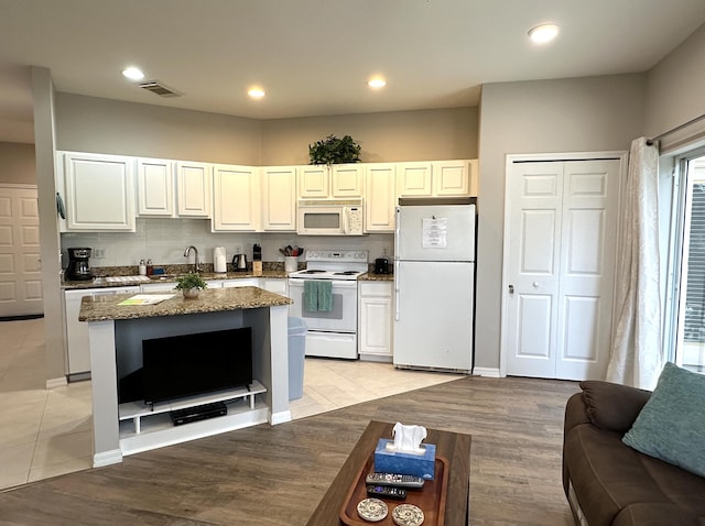 9851 Perfect Dr Unit 151, Port Saint Lucie, FL 34986 - kitchen with white appliances, light tile patterned floors, dark stone counters, a center island, and recessed lighting