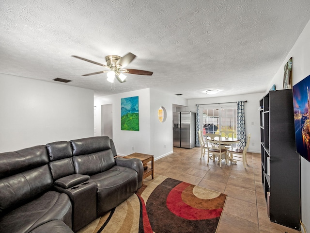 708 NW Floresta Dr, Port Saint Lucie, FL 34983 - living room with ceiling fan, light tile patterned floors, a textured ceiling, and baseboards