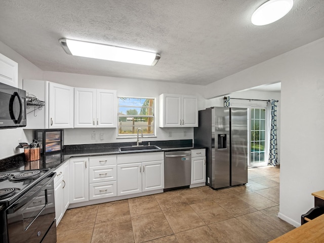 708 NW Floresta Dr, Port Saint Lucie, FL 34983 - kitchen with black appliances, a sink, dark countertops, white cabinets, and a textured ceiling