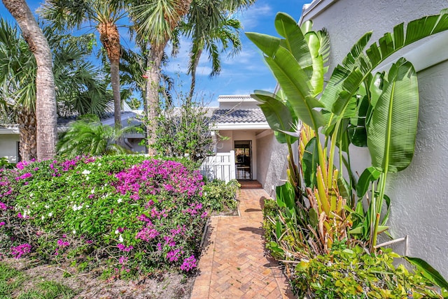 45 Eastgate Dr Unit B, Boynton Beach, FL 33436 - view of front of home featuring stucco siding, decorative driveway, an attached garage, a front yard, and a tile roof