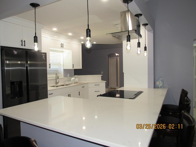 443 SW Homeland Rd, Port Saint Lucie, FL 34953 - kitchen featuring black electric cooktop, a kitchen breakfast bar, stainless steel refrigerator with ice dispenser, a sink, and white cabinets
