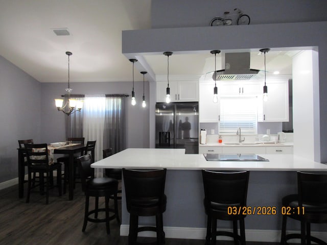 443 SW Homeland Rd, Port Saint Lucie, FL 34953 - kitchen featuring light countertops, a kitchen breakfast bar, black electric stovetop, stainless steel refrigerator with ice dispenser, and white cabinets
