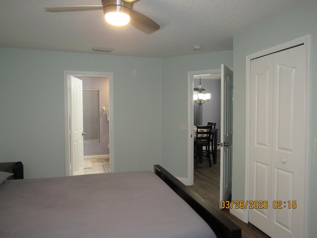 443 SW Homeland Rd, Port Saint Lucie, FL 34953 - bedroom featuring ceiling fan with notable chandelier, ensuite bath, visible vents, a closet, and wood finished floors