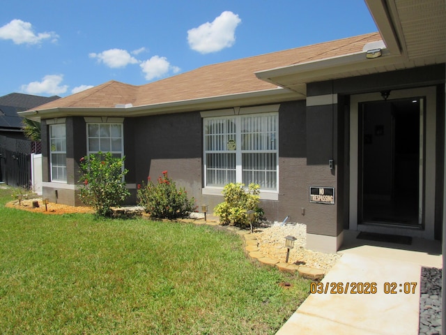 443 SW Homeland Rd, Port Saint Lucie, FL 34953 - doorway to property featuring stucco siding and a yard