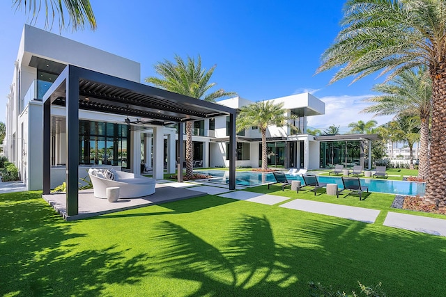 372 E Alexander Palm Rd, Boca Raton, FL 33432 - rear view of property with an outdoor pool, a patio area, stucco siding, and a lawn