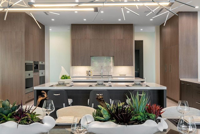372 E Alexander Palm Rd, Boca Raton, FL 33432 - kitchen with a sink, decorative backsplash, light countertops, and modern cabinets