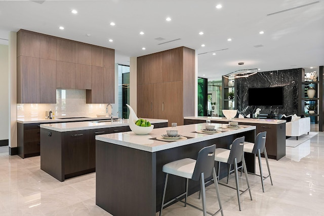 372 E Alexander Palm Rd, Boca Raton, FL 33432 - kitchen with light countertops, backsplash, a kitchen island with sink, modern cabinets, and a sink