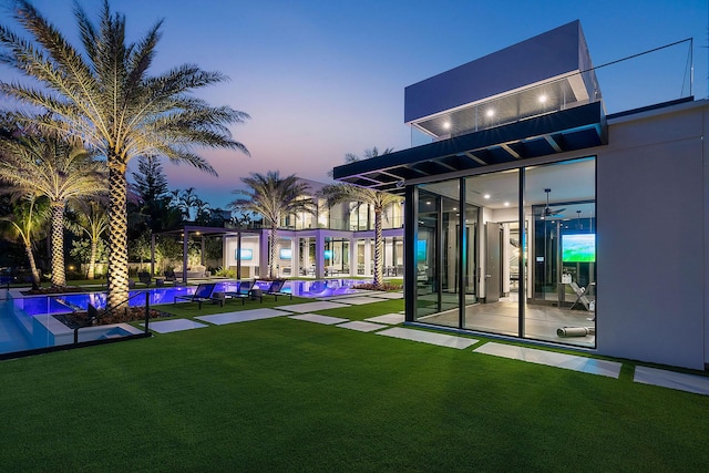 372 E Alexander Palm Rd, Boca Raton, FL 33432 - back of property at dusk featuring a yard