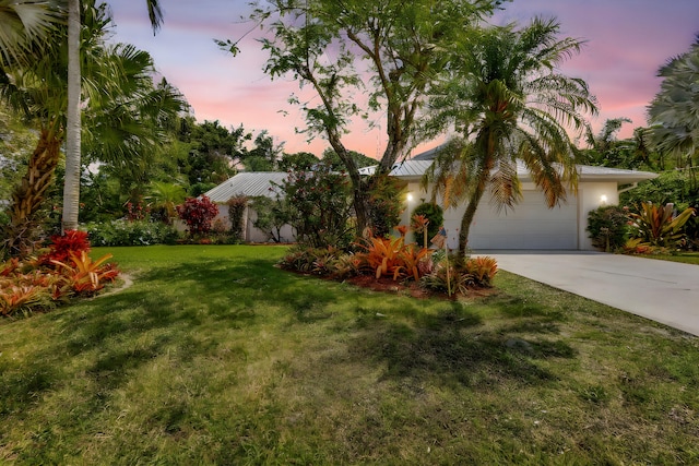 2101 SE Harlow St, Port Saint Lucie, FL 34952 - view of front of property featuring a yard, a standing seam roof, metal roof, a garage, and driveway
