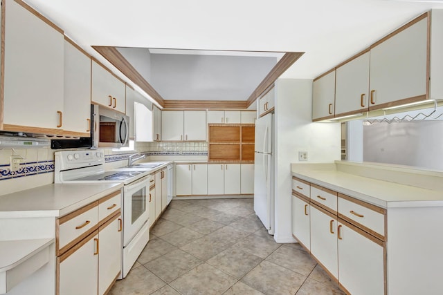 2101 SE Harlow St, Port Saint Lucie, FL 34952 - kitchen with decorative backsplash, a sink, a raised ceiling, light countertops, and white appliances