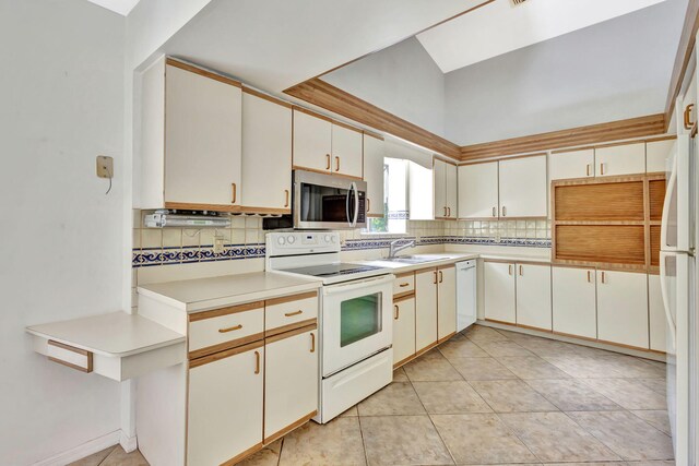 2101 SE Harlow St, Port Saint Lucie, FL 34952 - kitchen featuring a sink, white appliances, vaulted ceiling, backsplash, and light countertops
