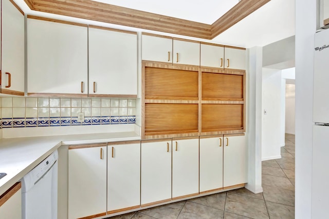 2101 SE Harlow St, Port Saint Lucie, FL 34952 - kitchen featuring light tile patterned floors, light countertops, white dishwasher, backsplash, and white cabinetry