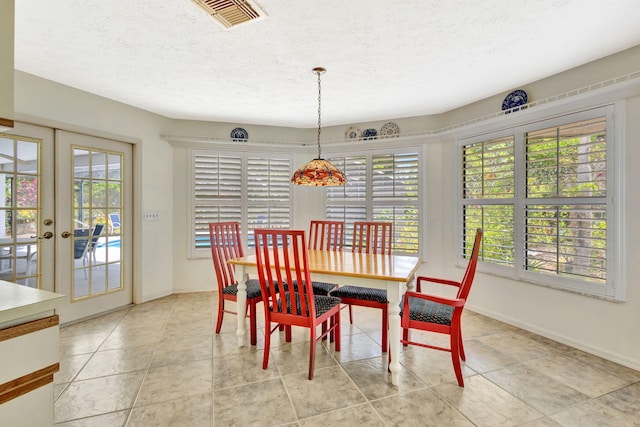 2101 SE Harlow St, Port Saint Lucie, FL 34952 - dining space with baseboards, visible vents, a textured ceiling, and french doors