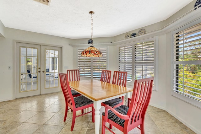 2101 SE Harlow St, Port Saint Lucie, FL 34952 - dining area featuring light tile patterned floors, a textured ceiling, french doors, and baseboards