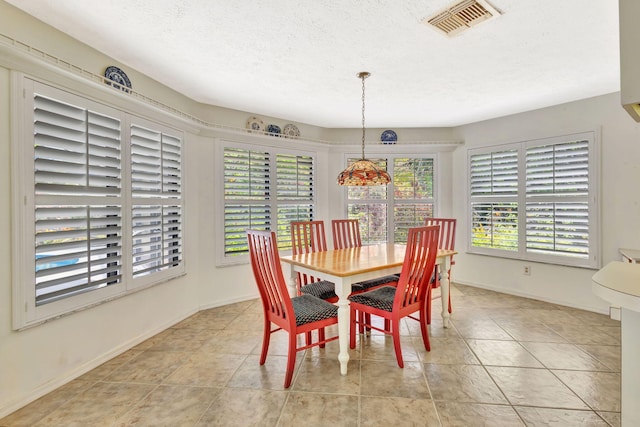 2101 SE Harlow St, Port Saint Lucie, FL 34952 - dining space featuring light tile patterned floors, a textured ceiling, visible vents, and baseboards