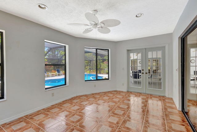 2101 SE Harlow St, Port Saint Lucie, FL 34952 - interior space with a textured ceiling, french doors, a ceiling fan, and baseboards