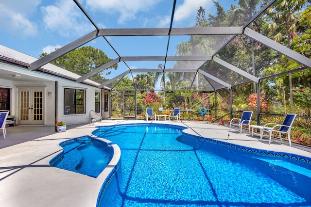 2101 SE Harlow St, Port Saint Lucie, FL 34952 - view of swimming pool with a patio, french doors, glass enclosure, and a pool with connected hot tub