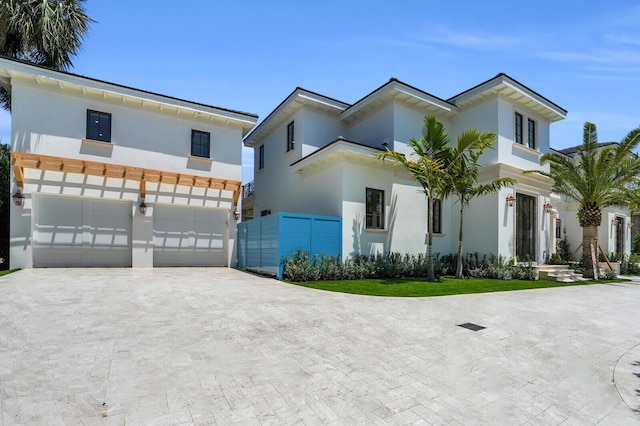 3408 Washington Rd, West Palm Beach, FL 33405 - modern home featuring driveway, an attached garage, and stucco siding