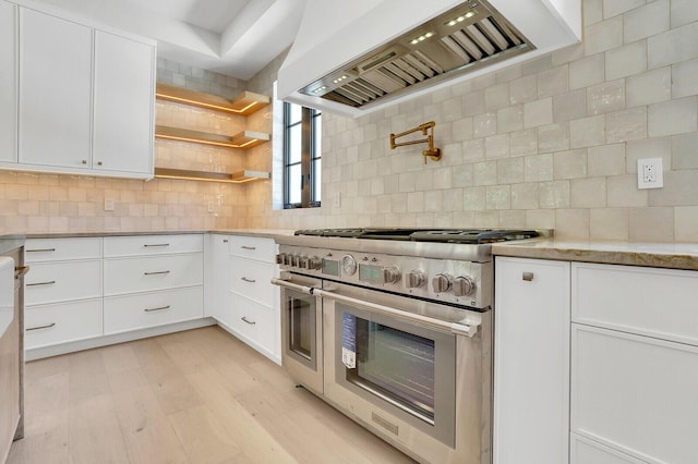 3408 Washington Rd, West Palm Beach, FL 33405 - kitchen with double oven range, custom exhaust hood, white cabinetry, backsplash, and light wood-style flooring