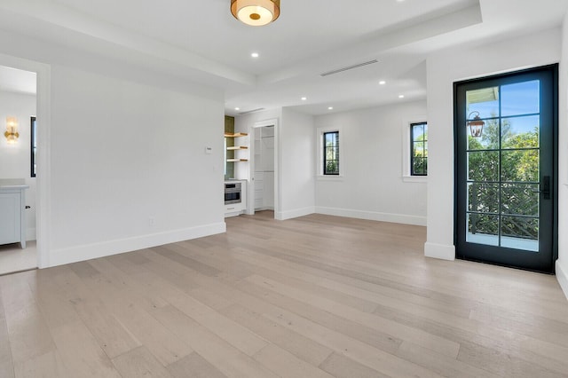 3408 Washington Rd, West Palm Beach, FL 33405 - unfurnished room with light wood finished floors, baseboards, recessed lighting, and a tray ceiling