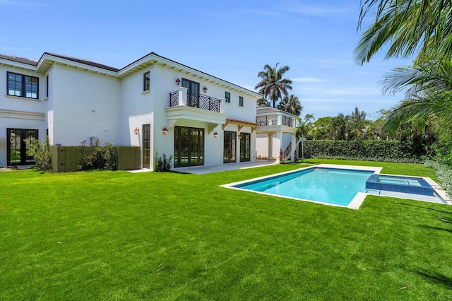 3408 Washington Rd, West Palm Beach, FL 33405 - rear view of house featuring a balcony, stucco siding, a pool with connected hot tub, and a patio area