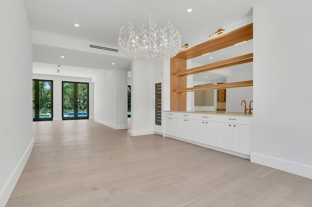 3408 Washington Rd, West Palm Beach, FL 33405 - unfurnished living room with light wood finished floors, recessed lighting, baseboards, a chandelier, and a sink