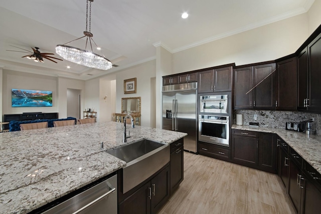 4673 Estates Cir, Westlake, FL 33470 - kitchen with appliances with stainless steel finishes, a sink, light stone countertops, crown molding, and hanging light fixtures