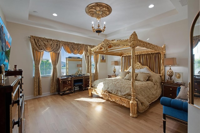 4673 Estates Cir, Westlake, FL 33470 - bedroom featuring a tray ceiling, a chandelier, light wood-type flooring, multiple windows, and recessed lighting