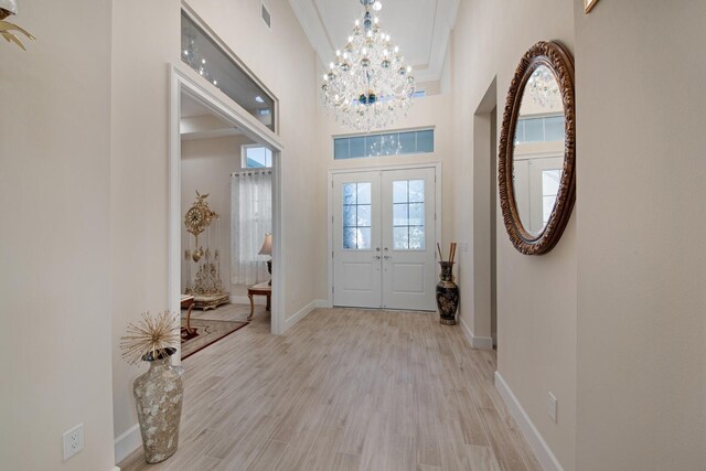 4673 Estates Cir, Westlake, FL 33470 - entryway with french doors, a chandelier, a high ceiling, light wood-style flooring, and baseboards