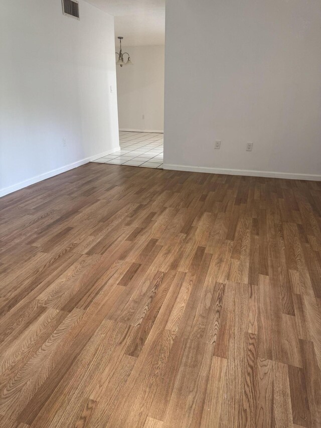 1681 NW 70th Ave Unit 102, Plantation, FL 33313 - unfurnished room with wood finished floors, baseboards, and a chandelier