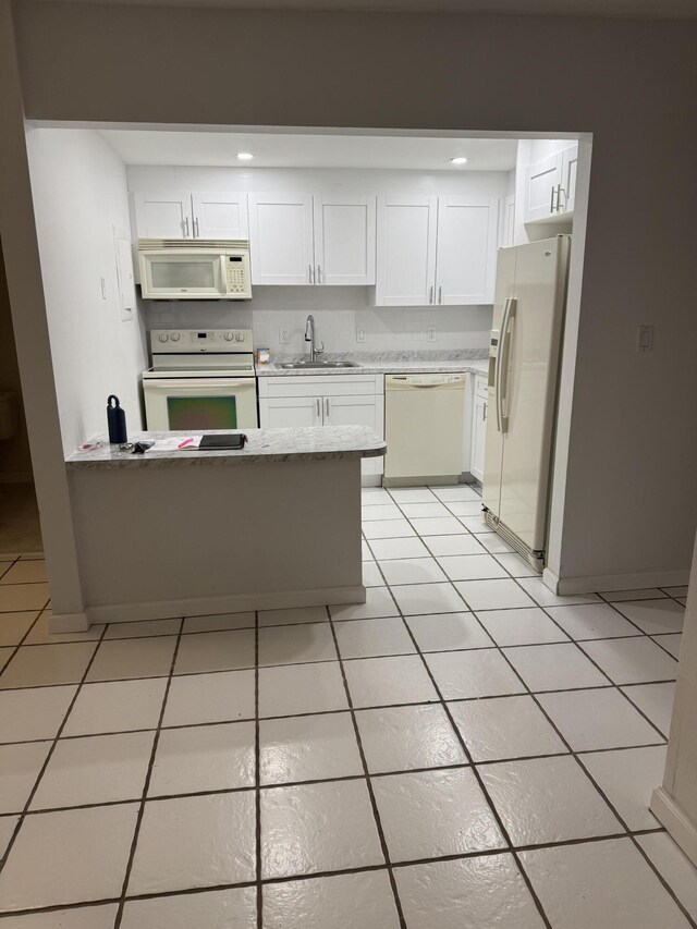 1681 NW 70th Ave Unit 102, Plantation, FL 33313 - kitchen featuring white appliances, a sink, white cabinets, light tile patterned flooring, and a peninsula