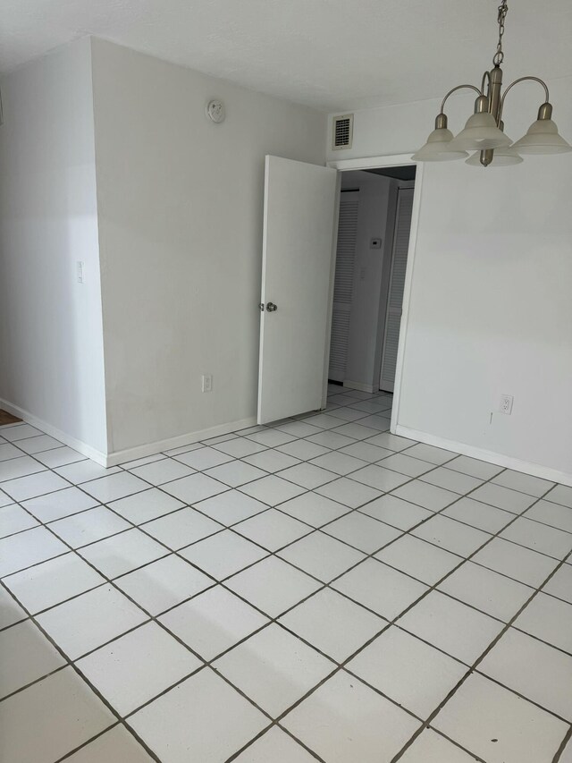 unfurnished room with baseboards and visible vents