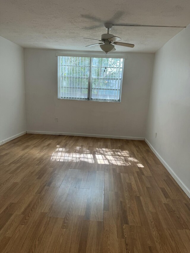 1681 NW 70th Ave Unit 102, Plantation, FL 33313 - spare room featuring a ceiling fan, baseboards, wood finished floors, and a textured ceiling