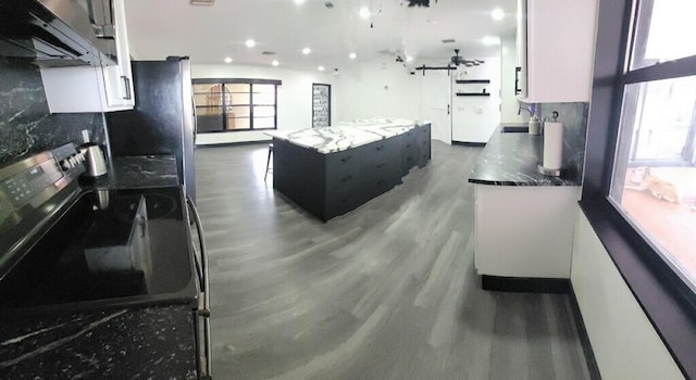 2379 Carambola Rd, West Palm Beach, FL 33406 - kitchen featuring electric range, ventilation hood, wood finished floors, a kitchen island, and recessed lighting
