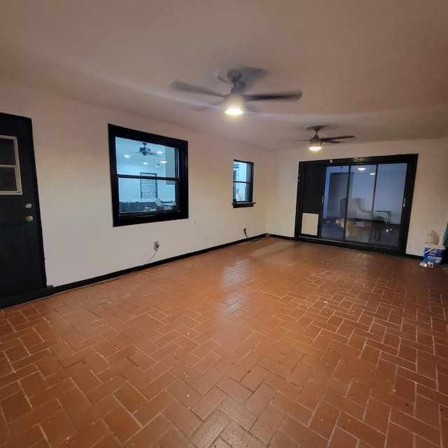 2379 Carambola Rd, West Palm Beach, FL 33406 - spare room featuring brick flooring, ceiling fan, and baseboards