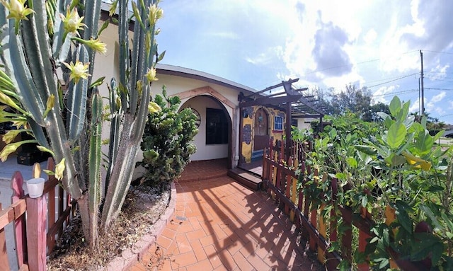 2379 Carambola Rd, West Palm Beach, FL 33406 - doorway to property with stucco siding and a pergola