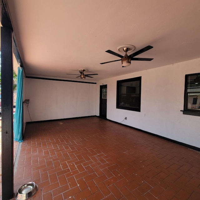 2379 Carambola Rd, West Palm Beach, FL 33406 - unfurnished room featuring brick flooring, a ceiling fan, and baseboards