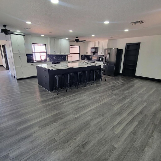 2379 Carambola Rd, West Palm Beach, FL 33406 - kitchen featuring appliances with stainless steel finishes, a spacious island, a breakfast bar area, ceiling fan, and recessed lighting