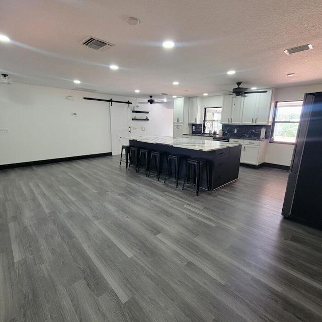 2379 Carambola Rd, West Palm Beach, FL 33406 - kitchen featuring a barn door, dark wood-style flooring, ceiling fan, freestanding refrigerator, and recessed lighting