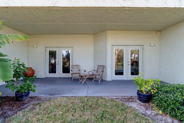 view of exterior entry with a patio and french doors