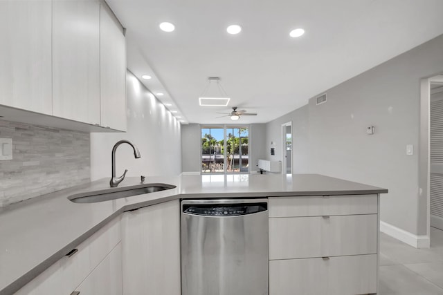 kitchen with a sink, backsplash, dishwasher, a peninsula, and visible vents
