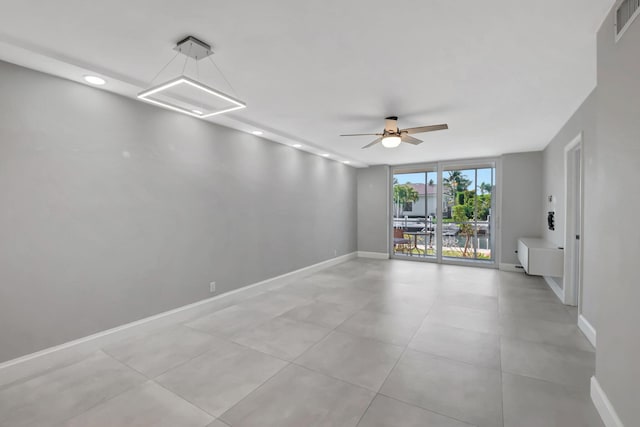 unfurnished room with baseboards, visible vents, a wall of windows, and a ceiling fan
