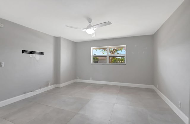 spare room featuring baseboards and a ceiling fan