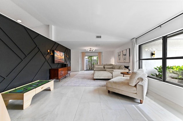 living area featuring lofted ceiling, visible vents, and baseboards