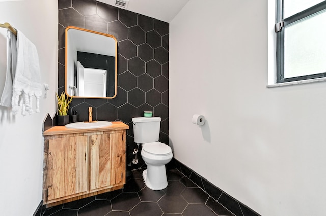 bathroom featuring vanity, tile walls, toilet, tile patterned flooring, and visible vents
