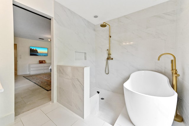 full bath with tile walls, tile patterned flooring, a walk in shower, and a freestanding bath