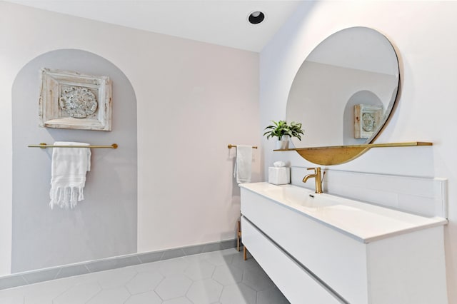 bathroom with baseboards, tile patterned flooring, and vanity