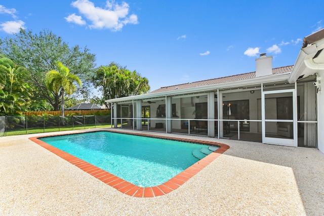 view of pool with a patio area, a ceiling fan, fence, a fenced in pool, and a sunroom